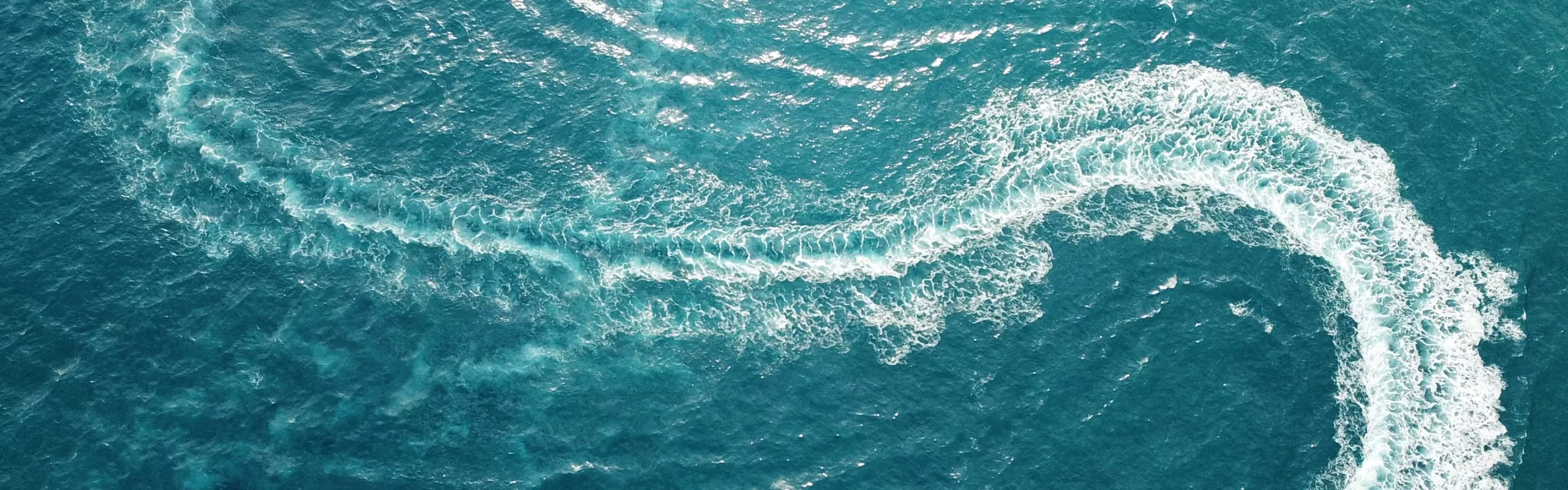 Meerwasser mit Wellen ausgelöst von einer Yacht